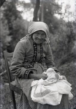 Starsza kobieta z szyciem na kolanach (w stroju laszki sądeckiej). Fot. ethnomuseum.pl